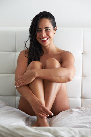 Sydney experienced personal trainer Ana Coppola posing on a bed for a professional photoshoot.